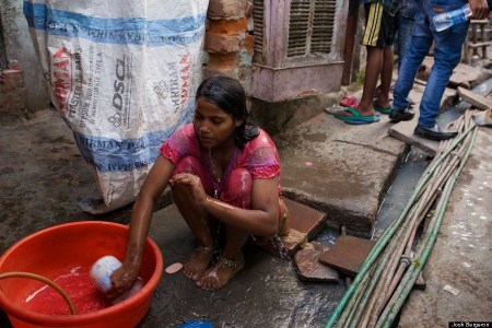 Washing next to the open plumbing system and water feeder lines of the Colony.