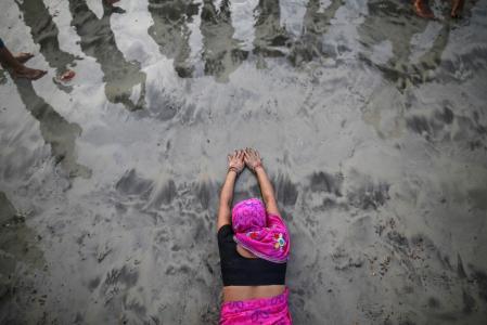 A Hindu devotee lies along the shores of the Arabian Sea as she offers prayers to the Sun god during the "Chhat" festival in Mumbai