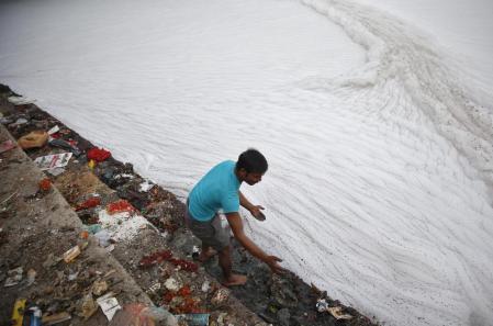 Man cleans the stairs on the banks of polluted river Yamuna before Hindu devotees started worshipping the Sun god Surya during the Hindu religious festival of Chatt Puja in New Delhi