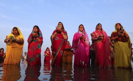 Hindu devotees pray while standing in the waters of the Arabian Sea as they worship the Sun god Surya during the Hindu religious festival Chatt Puja in Mumbai