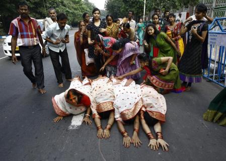 Hindu devotees lie on a road as they worship the Sun god Surya during the Hindu religious festival of Chatt Puja in Kolkata